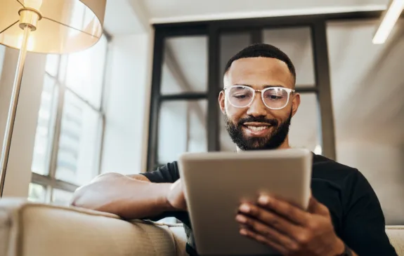 Black man viewing a tablet with a smile