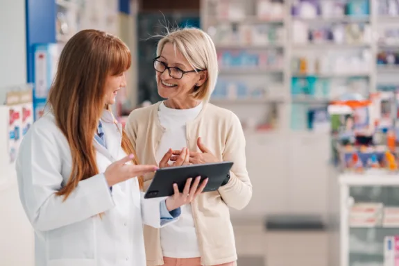 Pharmacist happily assists a customer in a cozy drugstore